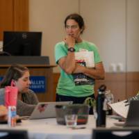 woman leading a small table discussion at a professional learning, seated indoors